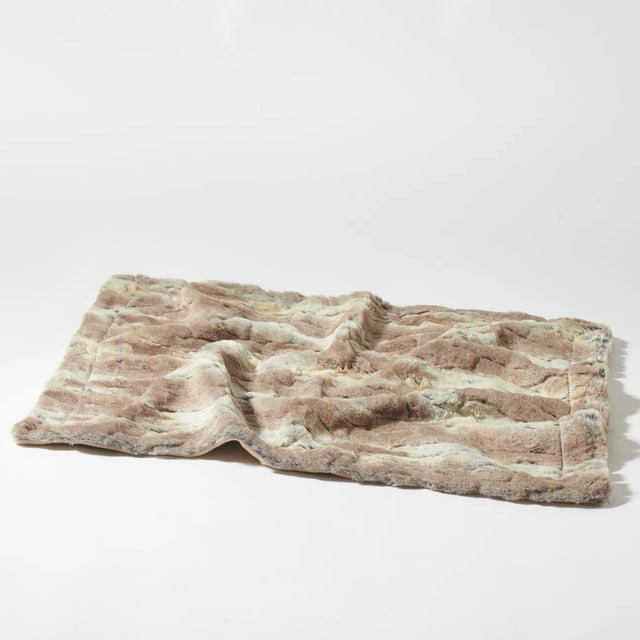 Présentation de la couverture pour chien en fausse fourrure sur fond blanc