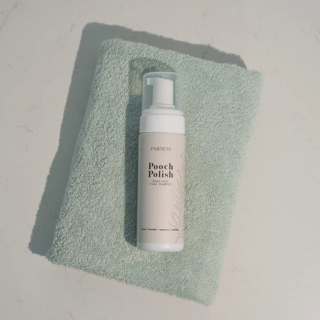 Présentation du flacon de shampoing sans rinçage sur une serviette