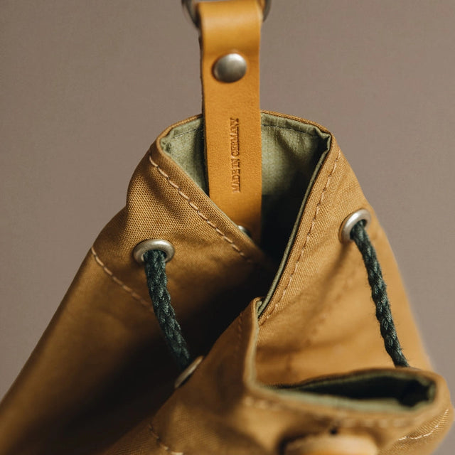 Présentation des finitions d'une pochette à friandises jaune pour chien 